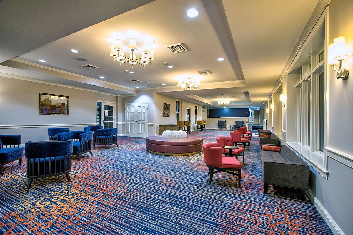 Spacious and colorful lounge area with various seating options and chandeliers